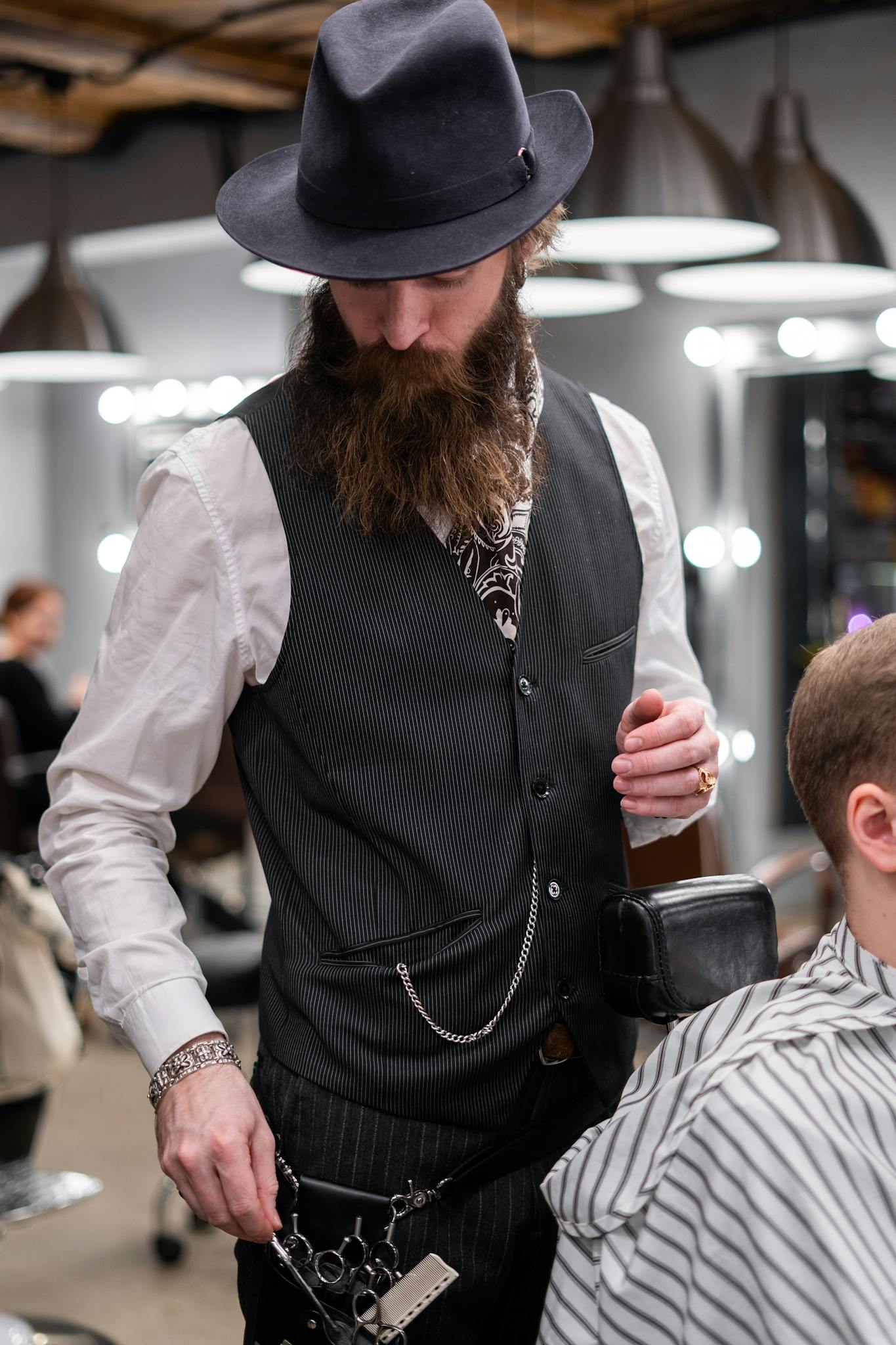 Man in Black Vest and White Long Sleeve Shirt Giving a Haircut
